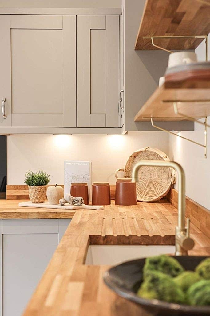 A stylish kitchen in a Huntingdon, York property, professionally staged by WildKind Interiors. Featuring butcher block countertops, sleek grey cabinetry, a brass faucet, open wooden...