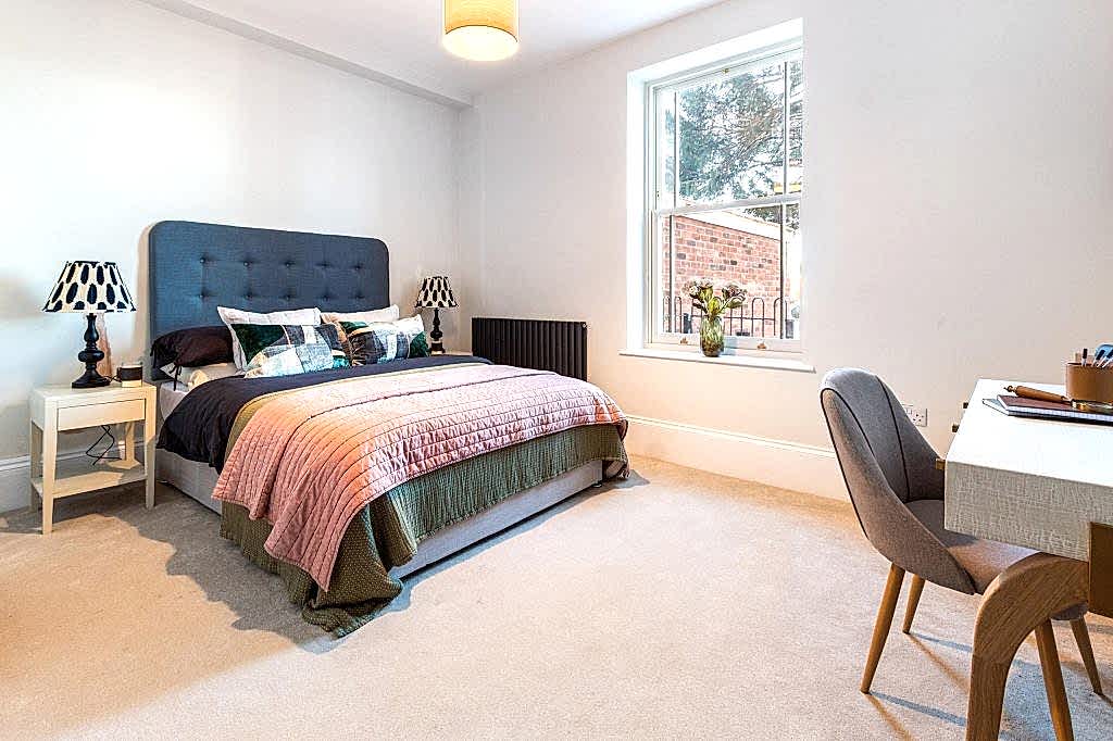 This elegantly styled bedroom in Scartho, Lincolnshire, is designed to appeal to prospective buyers through modern comfort and subtle touches. A deep blue, button-tufted headboard adds...