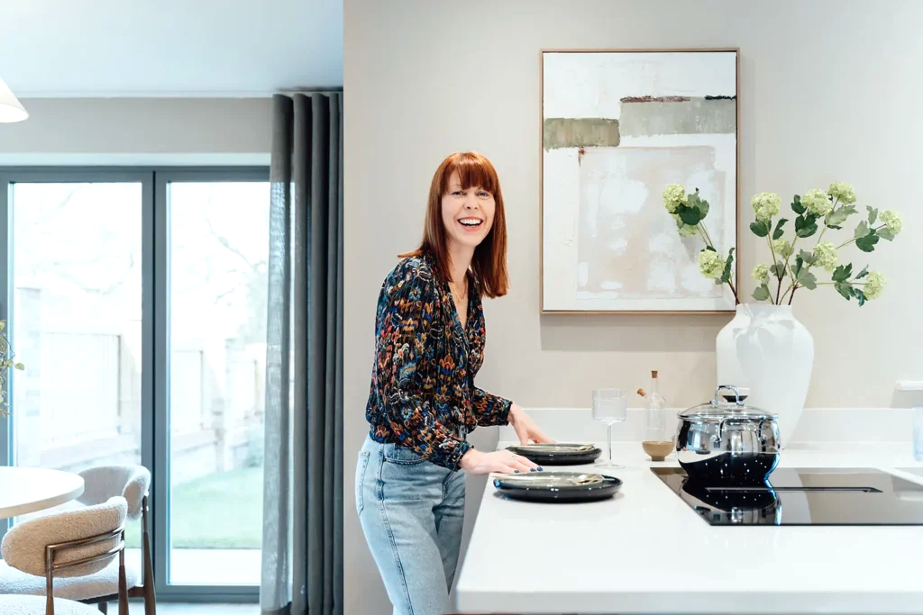 Louise Wynne putting the finishing touches to a show home kitchen, with styled tableware and fresh flowers.