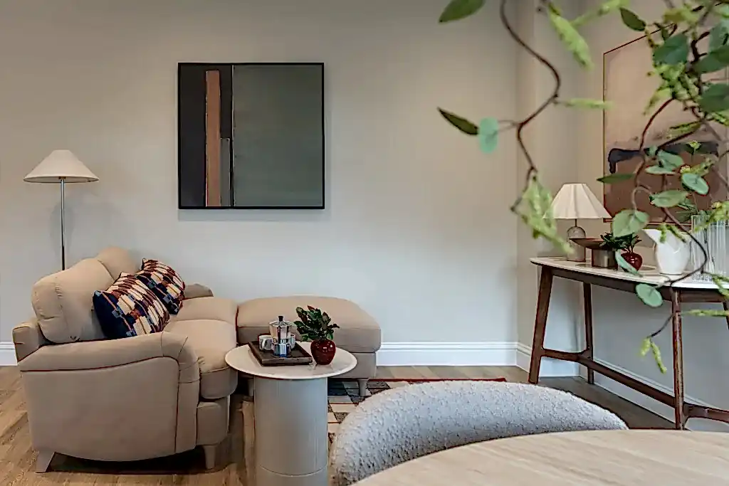 Living room with a neutral sofa, abstract artwork and a stone side table.