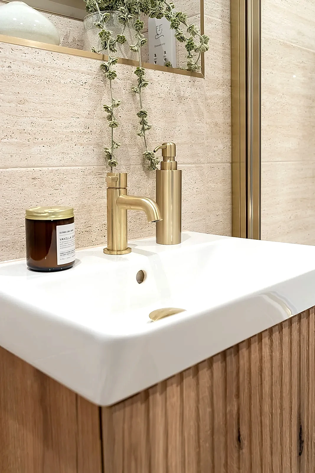 Show home bathroom with brushed brass tap and fluted wood vanity
